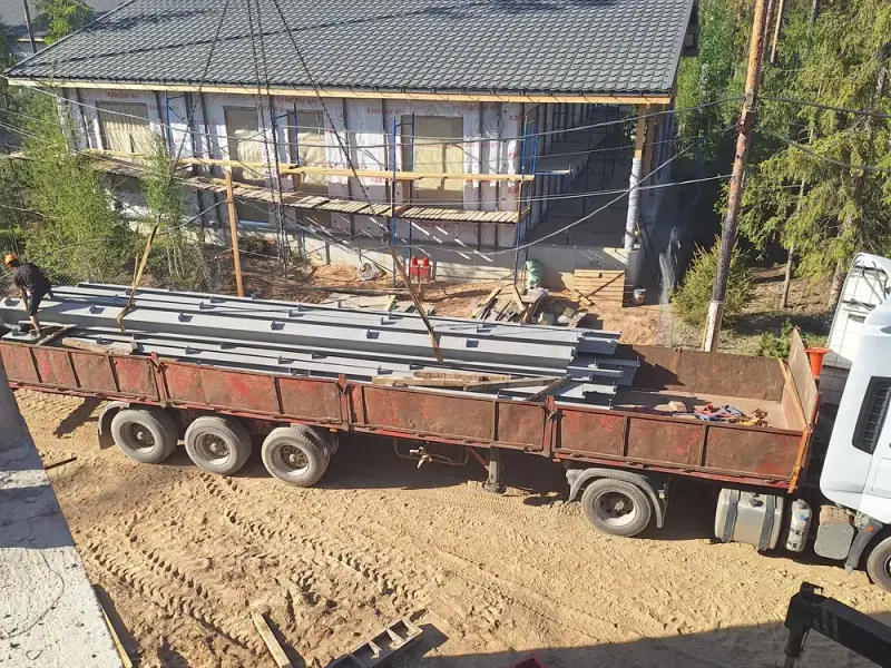 Разгрузка балок кровли краном на объекте в Ленинградской области